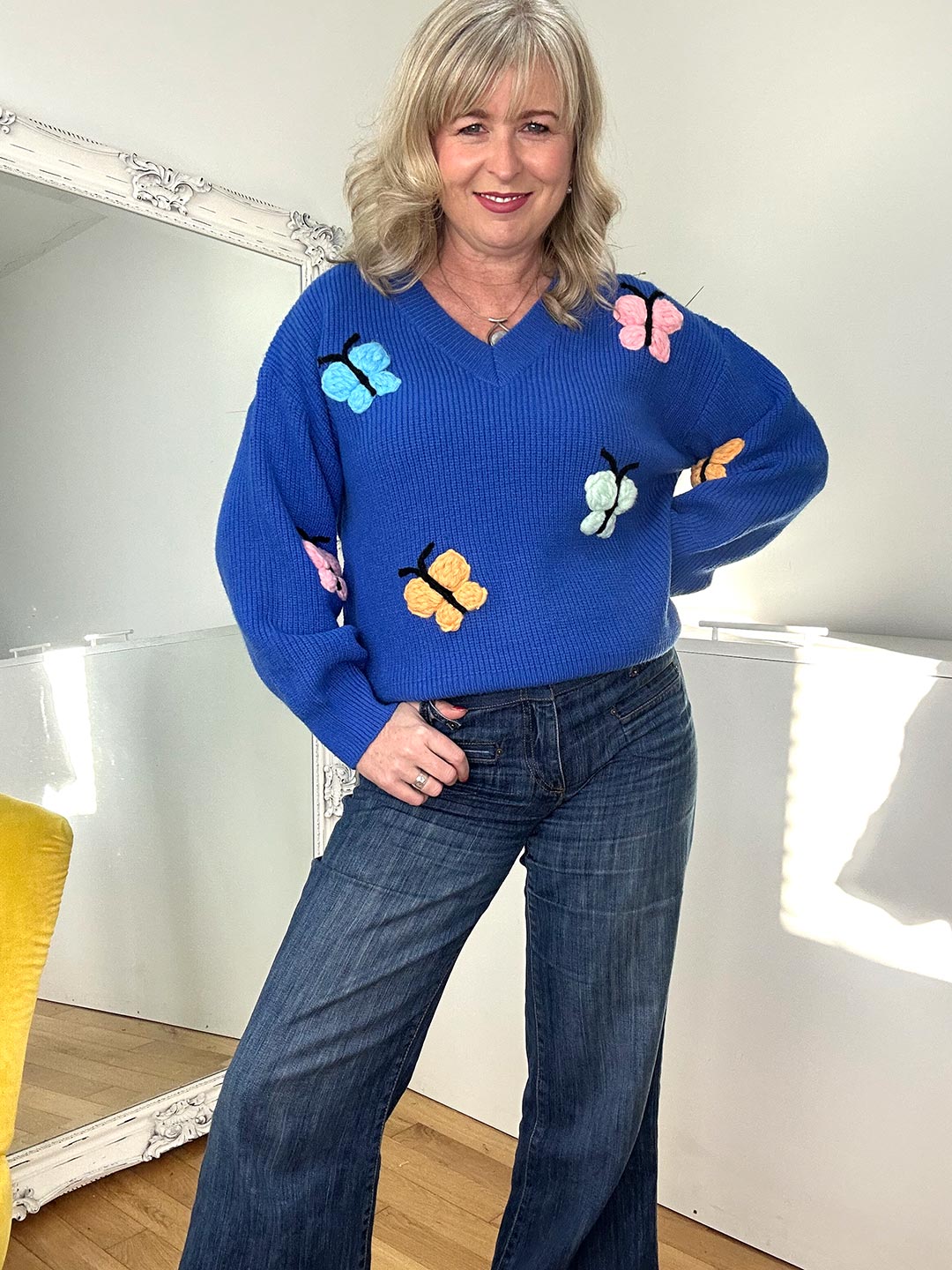 woman wearing a blue jumper with butterflies print